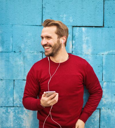 Man with earplugs in listening to the Level UP With Dave podcast from Next Level Chiropractic