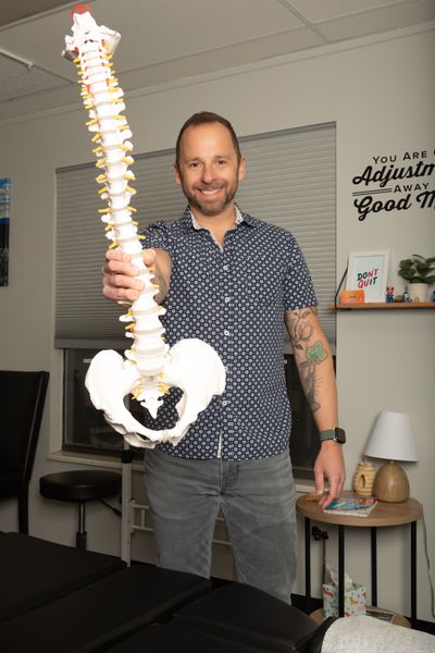 Chiropractor Dr. David Estis showing a model spine in his Centennial, Colorado office